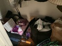 Overview photo showing items including umbrellas, hygiene products, and bags on floor near wall