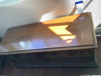 Top view of wooden chest showing rectangular polished surface with signs of wear and scratches.