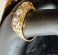 Front view showing three round diamonds set in engraved bar top