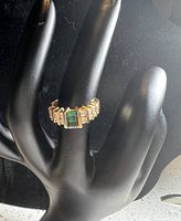 Front view of ring showing emerald center and diamond accents