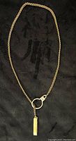 Full-length view of 14kt yellow gold chain laid flat on black background