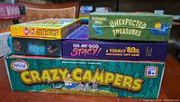 Five board and card games stacked: SkipBo, Flip City, Unexpected Treasures, Oh My God Stacy!, Crazy Campers