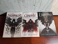 Three Nevernight Chronicle novels by Jay Kristoff: Nevernight, Godsgrave, and Darkdawn, paperback with illustrated covers featuring dark fantasy themes.