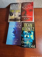 Photo of four Dean Koontz paperback books showing titles: The City, The Whispering Room, Forever Odd, Deeply Odd