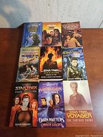 Photo showing 9 Star Trek books with colorful covers, including titles by authors Susan Wright, Christie Golden, and others.