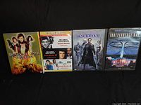 Front display of four DVDs including Resident Evil Trilogy, Matrix, Independence Day, and Police Academy showing cover art and titles.