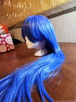Long soft blue fantasy wig shown on white mannequin head with smooth texture and thick bangs.