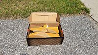 Shoes inside original box showing mustard yellow suede loafers.