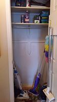 Photo of closet with Bissell SpotClean, Swiffer mop, and other cleaning supplies visible on floor and shelves.