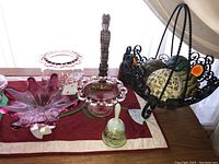 Overview of all items together including glass bowl, wooden figures, ceramic bell and basket with ceramic balls.