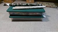 Two stacked green Rubbermaid totes with gift wrap rolls on top, showing general size and storage.