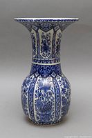 Front and side views of the Delft vase showing blue floral designs and flared rim.