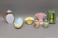 Seven vintage mid-century pottery pieces arranged on grey background, showing all items in the lot including various vases, bowls, and creamer.