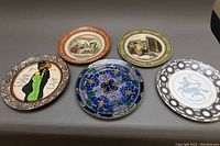 Overview of all five plates laid out on gray surface showing difference in designs and colors
