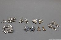 Full lot showing a 2-inch Jay Flex sterling silver brooch and six pairs of assorted vintage crystal costume earrings including Sherman and Continental styles