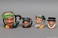 Front view of all four Toby mugs in a row showing detailed facial expressions and colors.
