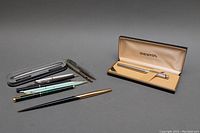 All pens displayed with Sheaffer pen in original case visible, showing variety of vintage pens in the lot.