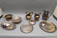 Full arrangement of vintage silver plated servingware showing bowls, trays, pitchers, and sugar bowl
