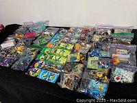 Overview of multiple sealed plastic bags on black surface, containing assorted Lego pieces and instruction manuals.