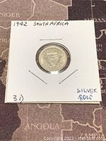 Front side of the 1942 South African silver 3 pence coin showing the South African coat of arms.