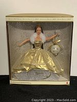 Front view of Barbie Celebration Teresa doll in original box with gold dress and crown.