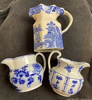 Top view showing three ceramic pitchers with blue and white patterns.