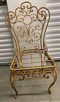 Single iron garden chair showing detailed scroll design and open seat frame