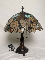 Full view of the Tiffany style stained glass lamp showing stained glass shade and metal base