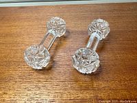 Two lead crystal utensil rests placed parallel on a wooden surface, showing overall design and condition.