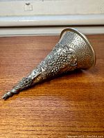 Full view of pewter funnel showing twisted tapered tip and detailed grapevine decoration along the body.