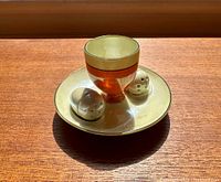 Noritake lustre egg coddle with matching salt and pepper shakers on the round dish tray.