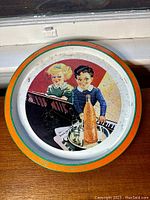 Full view of round vintage Orange Crush metal tray with colorful graphic of children at piano and bottle on tray in center, showing overall condition and wear.