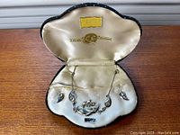 Vintage sterling silver necklace and matching earrings displayed in original satin-lined box with label.