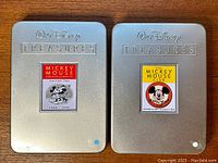 Front view of two Walt Disney Treasures DVD metal tins featuring Mickey Mouse Black and White and Mickey Mouse Club sets with clear labels.