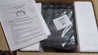 Disco strobe light in original packaging with styrofoam padding and user manual on top.