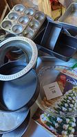Photo showing muffin tin, springform pan, square cake pans, round cake pans, loaf pans stacked together