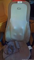 Full view of the padded computer chair equipped with the Homedics massager cushion attached. Light beige mesh on massager area with Homedics branding.