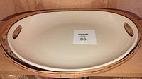 Top view of ivory colored pottery handled contour tray platter with smooth interior surface