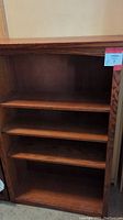 Front view of oak bookshelf showing 3 shelves.