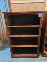 Front view of the oak bookcase showing three shelves and wood grain finish.