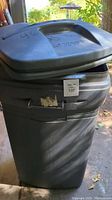 Gray Rubbermaid rolling trash can with hinged lid