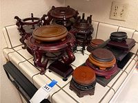 Group view of multiple wooden and metal display stands on a tiled countertop