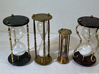 Four hourglasses shown side by side highlighting size and design differences