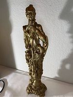 Full view of the plaster statue highlighting the intricate details and gold finish.