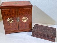 Both Far East style jewelry boxes displayed side by side on a light floor showing relative sizes and aesthetics.