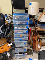 Full view of plastic storage unit with eight translucent drawers and adjoining floor lamp