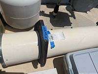 Side view of handcrafted telescope tube with mounting bracket and measurement tags.