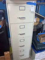 Closed view of the metal 4-drawer file cabinet showing all four drawers with label holders and handles.