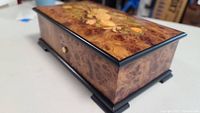 Top view showing lid with burl wood veneer and decorative inlay