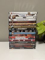 Stacked DVDs showing 19 movie titles on spines and covers
